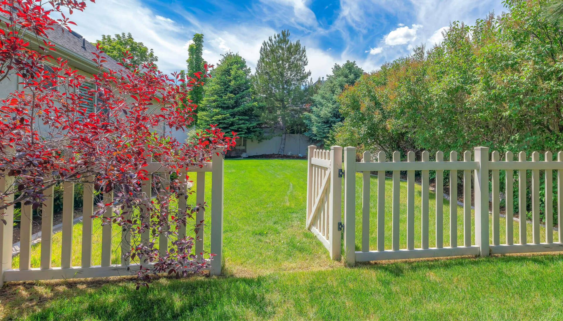 A functional fence gate providing access to a well-maintained backyard, surrounded by a wooden fence in Wichita
